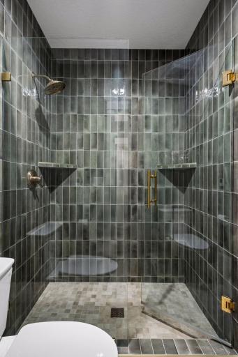 Floor-to-ceiling handcrafted tile and premium fixtures create a luxurious spa-like experience.