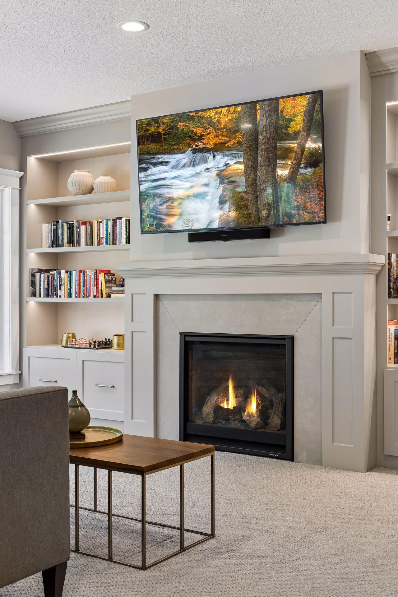 Architectural millwork and tailored built-ins frame a striking fireplace that anchors the lower level.