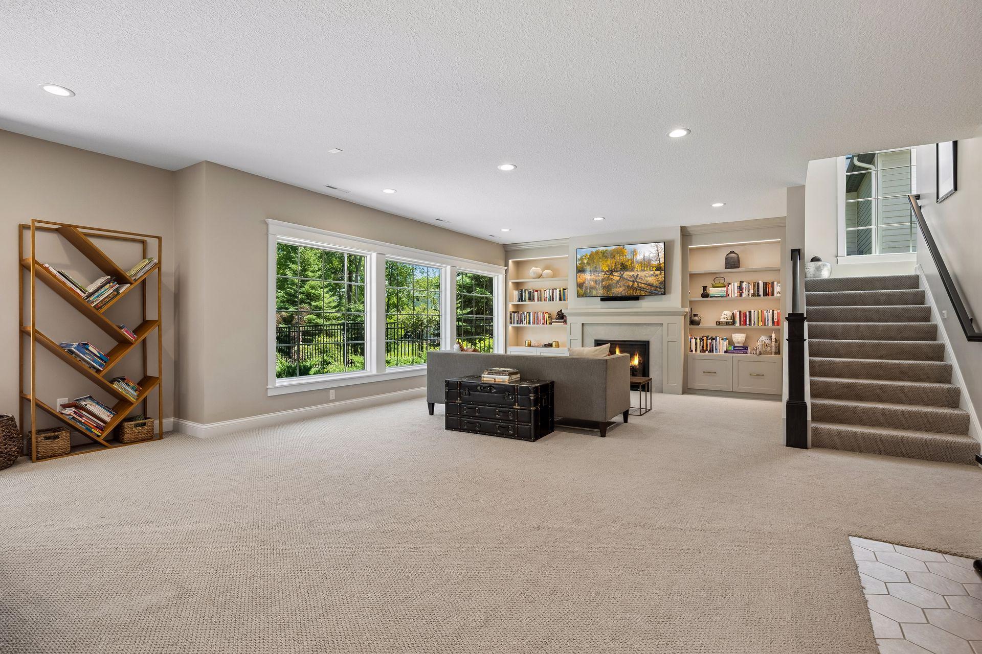 Walls of oversized windows invite the surrounding landscape inside, filling the lower level with remarkable natural light.