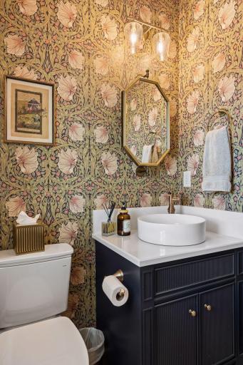 Wrapped in dramatic designer wallpaper and accented with rich brass fixtures, the powder room offers a memorable boutique-hotel experience.