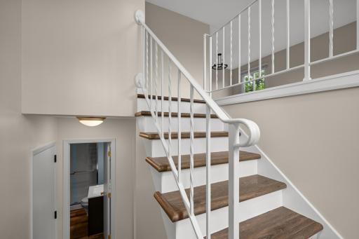 Welcoming split-entry design featuring updated flooring and an open staircase that enhances the home's bright and airy feel.