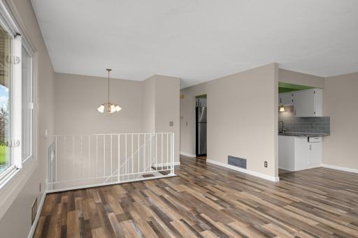 Spacious main living area showcasing an open-concept design, updated flooring, and a functional layout that connects the living, dining, and kitchen spaces.
