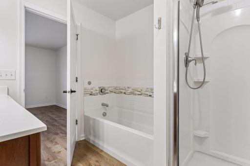 Upper level primary bathroom with separate tub and shower.
