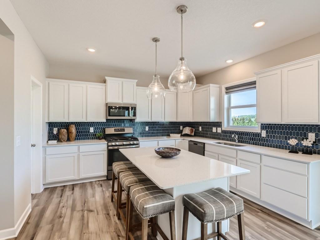 Photo is of the actual model. Fantastic open kitchen with ample counter space and high end included features!
