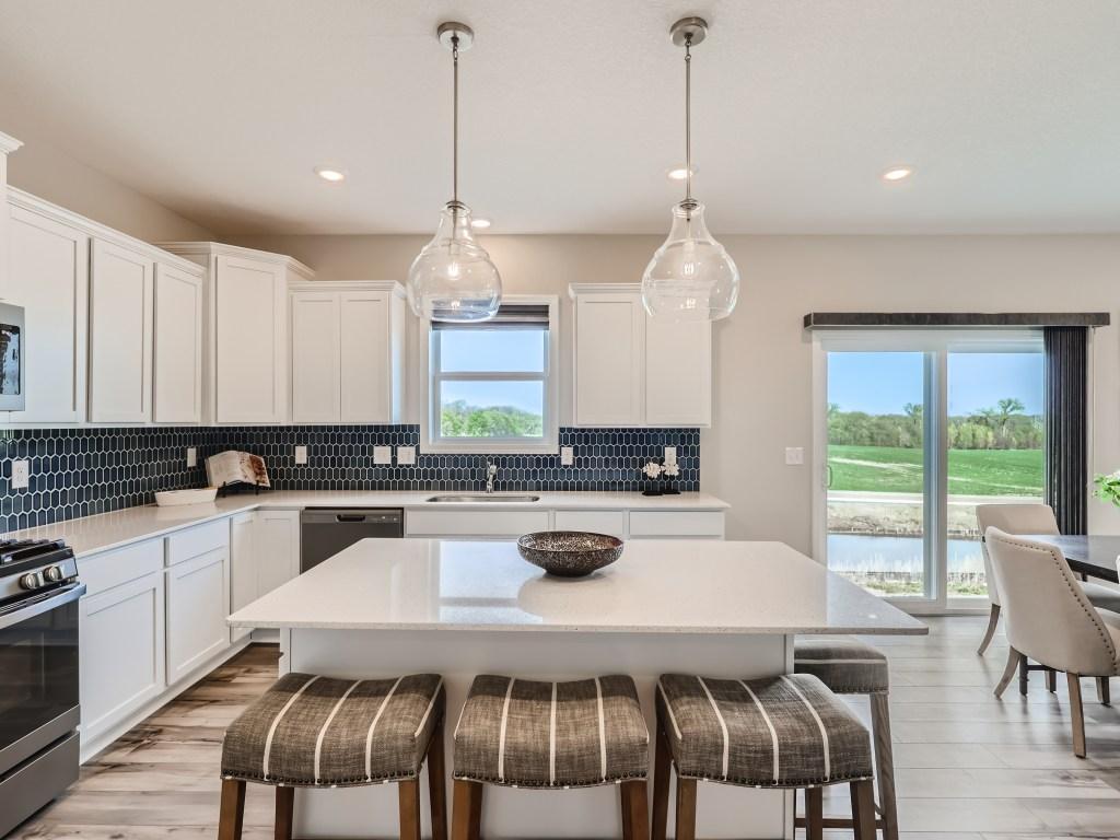 Photo is of the actual model. Timeless white cabinetry with and elegant backsplash. Let's build one for you!