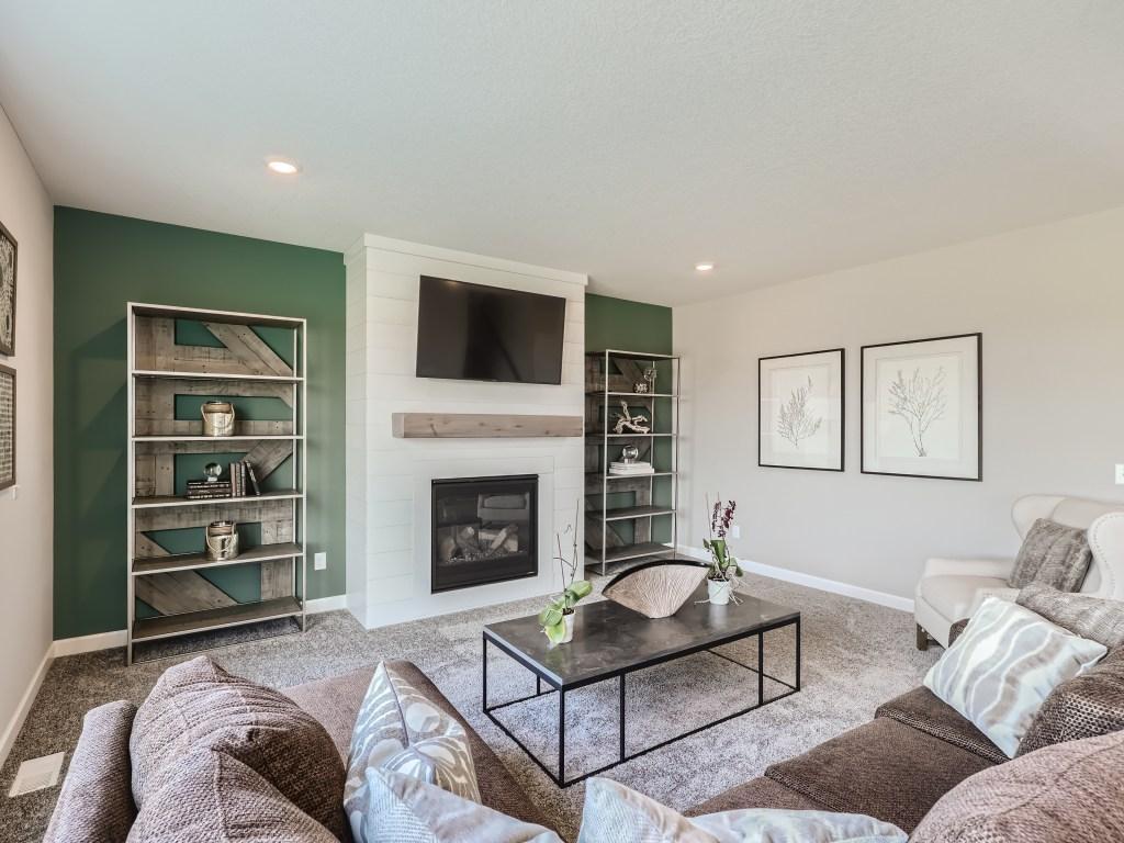 Photo is of the actual model. Main level family room is comfortable and enhanced by the open concept design.