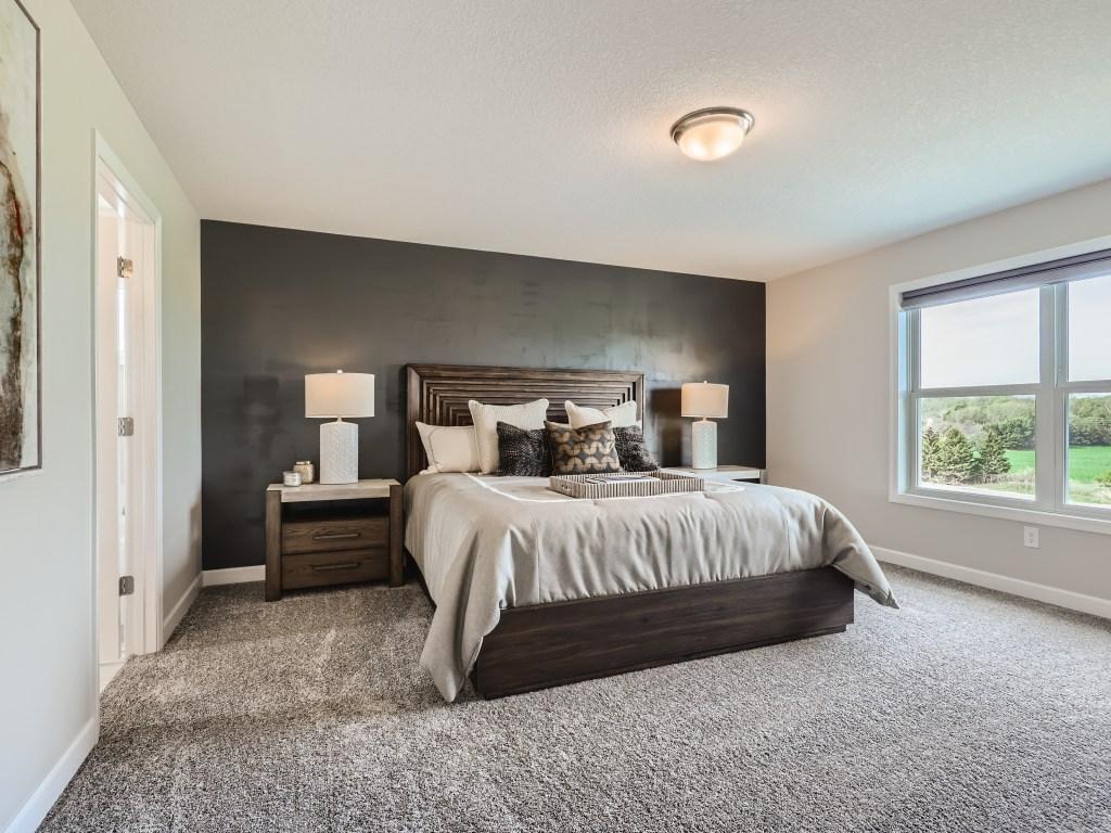 Photo is of the actual model. Primary bedroom is a treat with sun drenched walls and room to roam.
