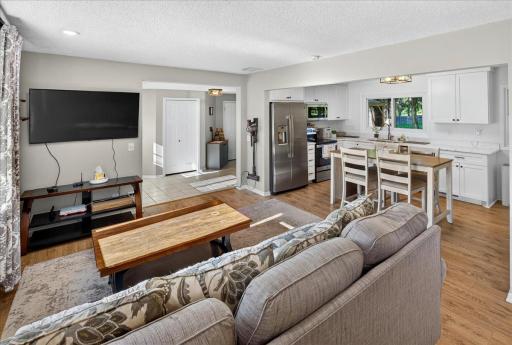 Spacious open-concept design showcasing a light-filled open floor plan connecting the living room, foyer, and kitchen with stylish finishes and functional design.