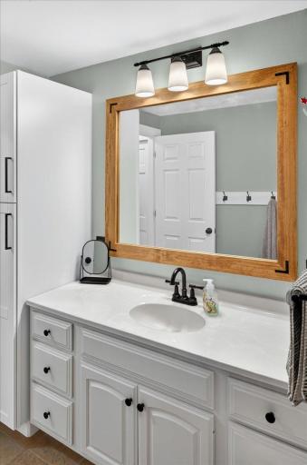 The updated main-floor bath offers modern comfort, featuring a ceramic tile, relaxing Jacuzzi tub, generous counter space, and abundant storage.