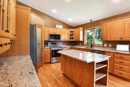 This kitchen is where the heart of the home really shines ~ brand new granite tops adorn the huge center island and countertops