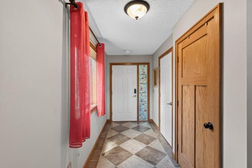 View of front entry to front door, garage entry and closet on right