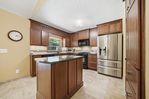 The kitchen offers plenty of cabinet space, granite countertops, and a beautiful window over the undermount sink with views of the backyard. You might even find yourself volunteering to do the dishes!