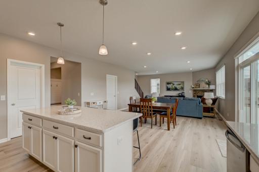 The bright, open-concept main level is filled with natural light and features a cozy stone fireplace, fresh paint, new flooring, and a dedicated home office or sitting room just off the entry.