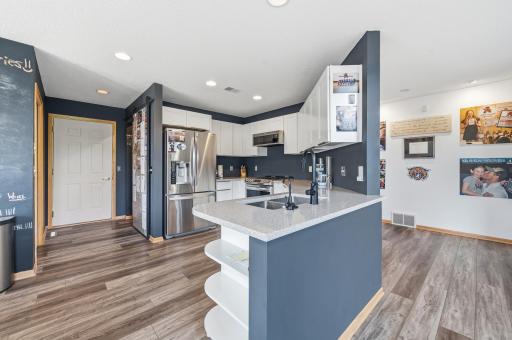 The modern kitchen boasts crisp white cabinetry complemented by a sleek hard-surface countertop.