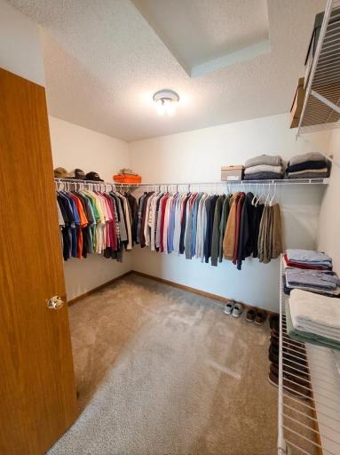 Oversized walk-in closet with extensive hanging space and built-in shelving.