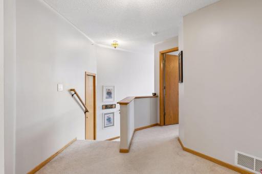 A versatile loft at the top of the stairs offers an ideal setting for a home office, study, library, or cozy retreat, adding valuable flexible living space.