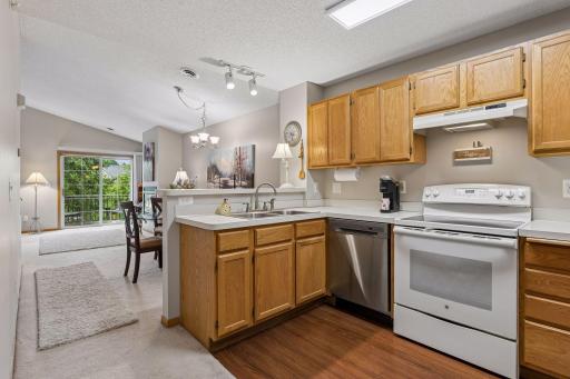 The open, highly functional kitchen features a raised breakfast bar, abundant workspace, and easy-to-maintain vinyl flooring, making it ideal for both everyday living and entertaining.