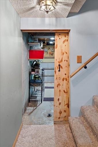 knotty pine barn door separates the utility/storage area from the family room
