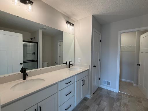 Dual vanity in the private en-suite bath provides maximum functionality. Features a large shower.