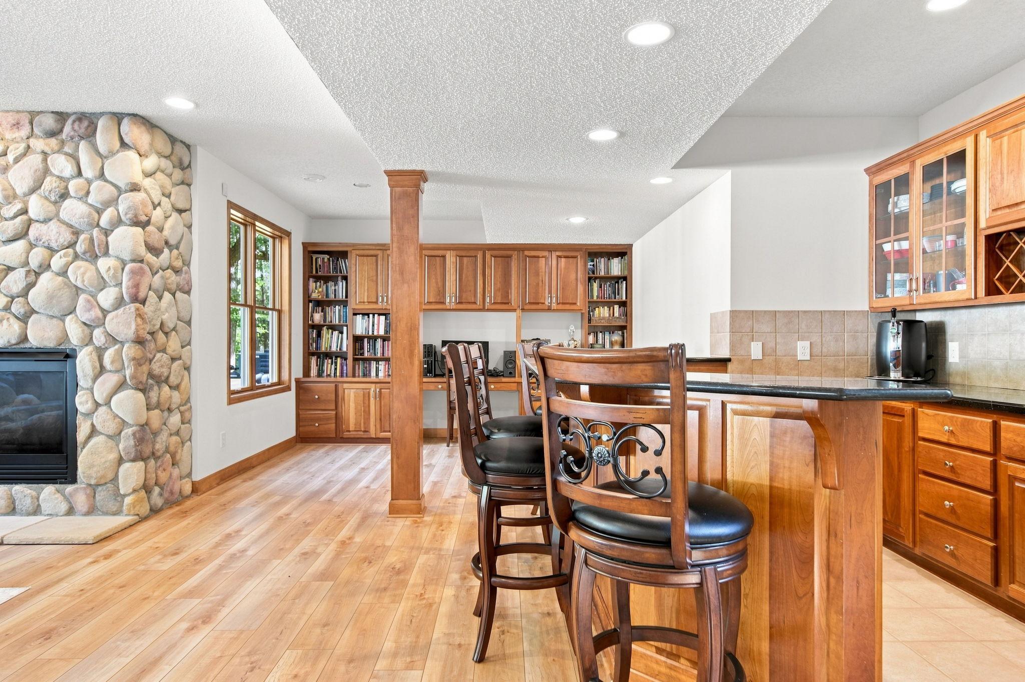 The lower level is decked out with wet bar, movie theater projector, entertainment builts, office and book case built ins and Bonus room