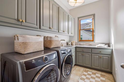 Refreshed main floor laundry with new washer, dryer, sink and faucet. Quartzite countertops and new lighting.