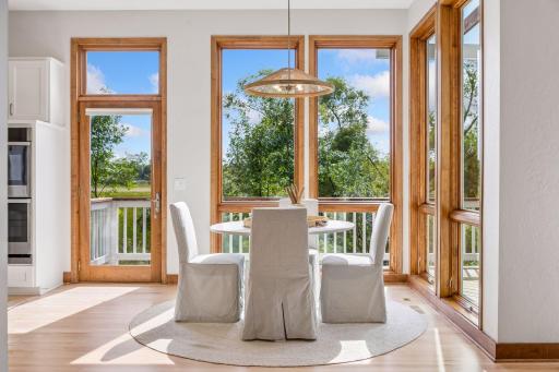 Informal dining area with new lighting and maple hardwood floors. Door leads to deck.