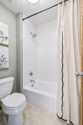 Jack and Jill bath has tub shower with new tile surround.