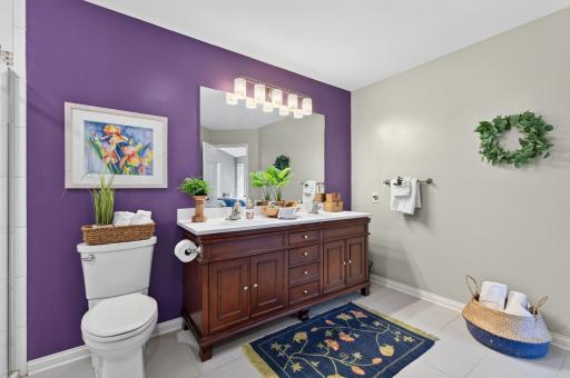 The beautifully updated primary walk-through bathroom with walk-in shower