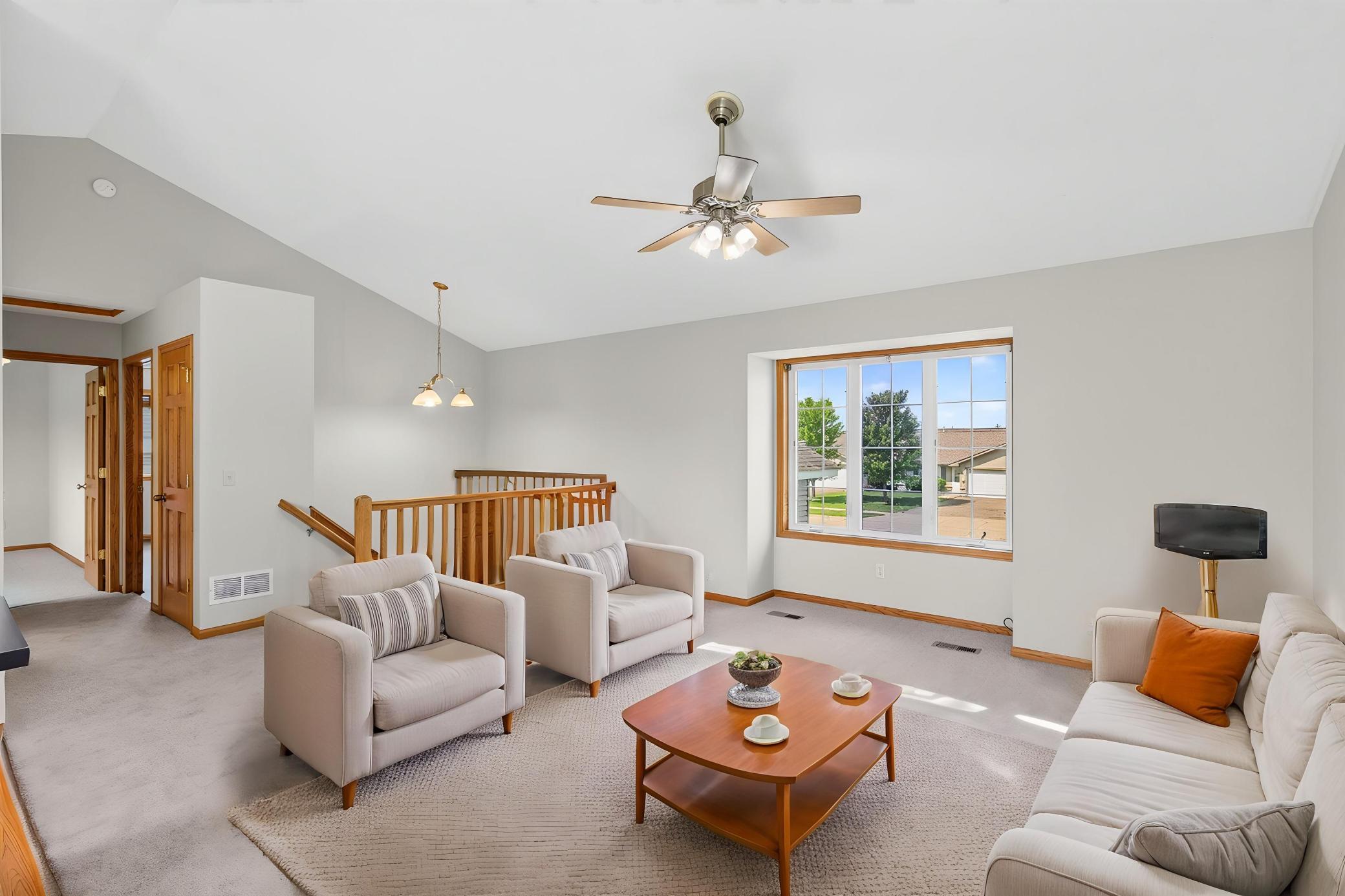 This spacious living room feels even larger than it is thanks to soaring vaulted ceilings and large windows that flood the space with natural light.