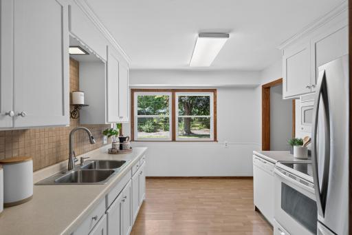 Functional kitchen with abundant cabinetry, generous prep space, and backyard views.