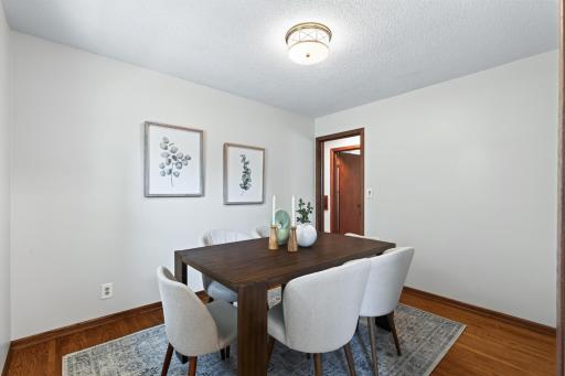 Dedicated dining room with hardwood floors and custom accordion blinds.