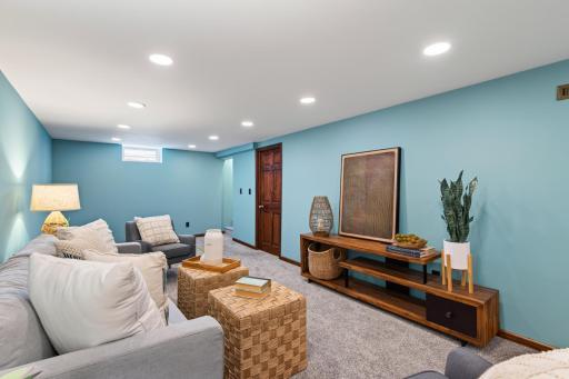 Spacious finished lower-level family room with updated carpet and recessed lighting.