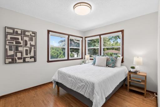 Main-level corner bedroom featuring hardwood floors and windows on two sides.