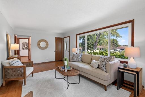 Sun-filled living room with an expansive picture window and hardwood floors.