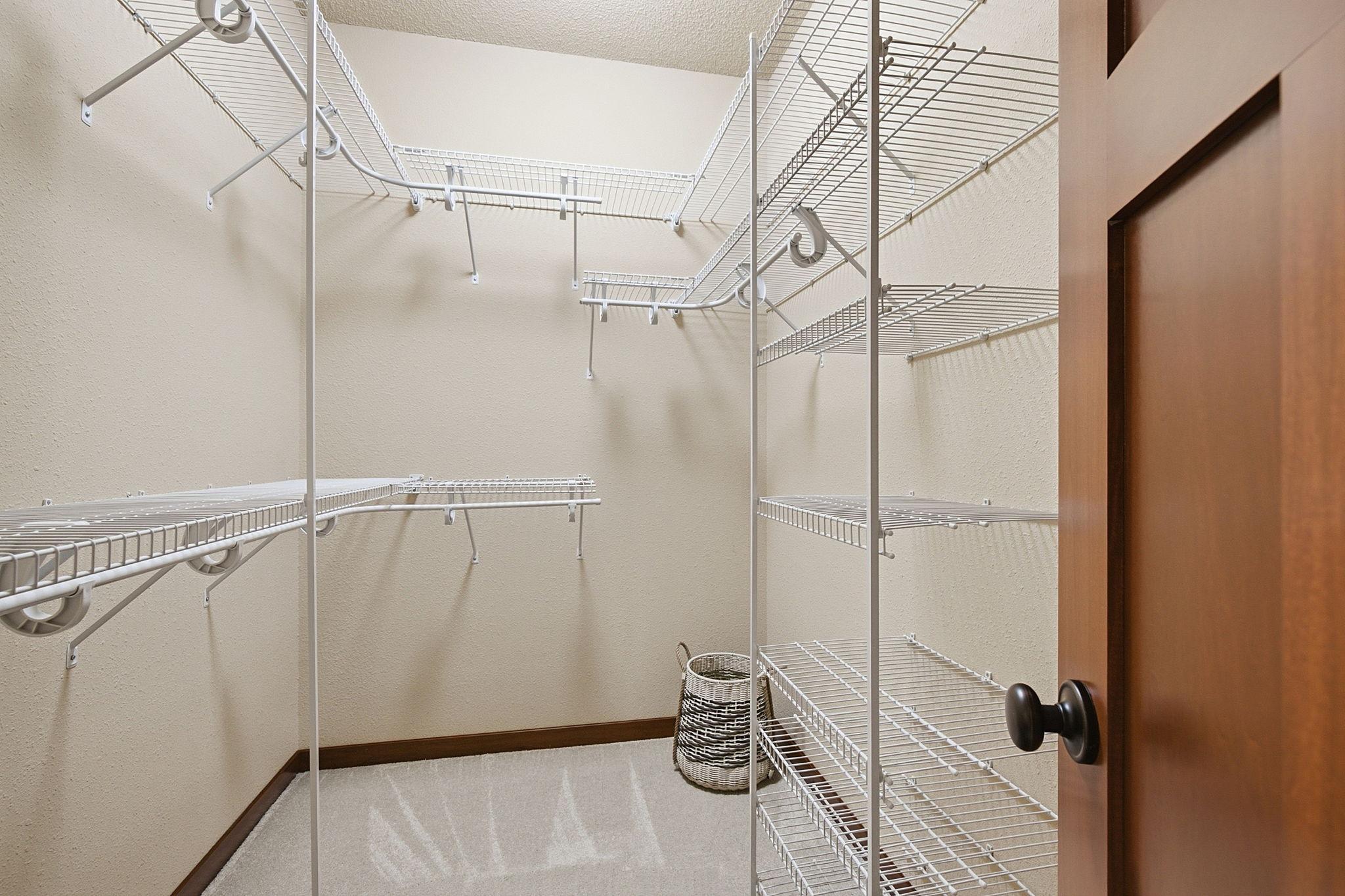 Walk in primary closet with shelving