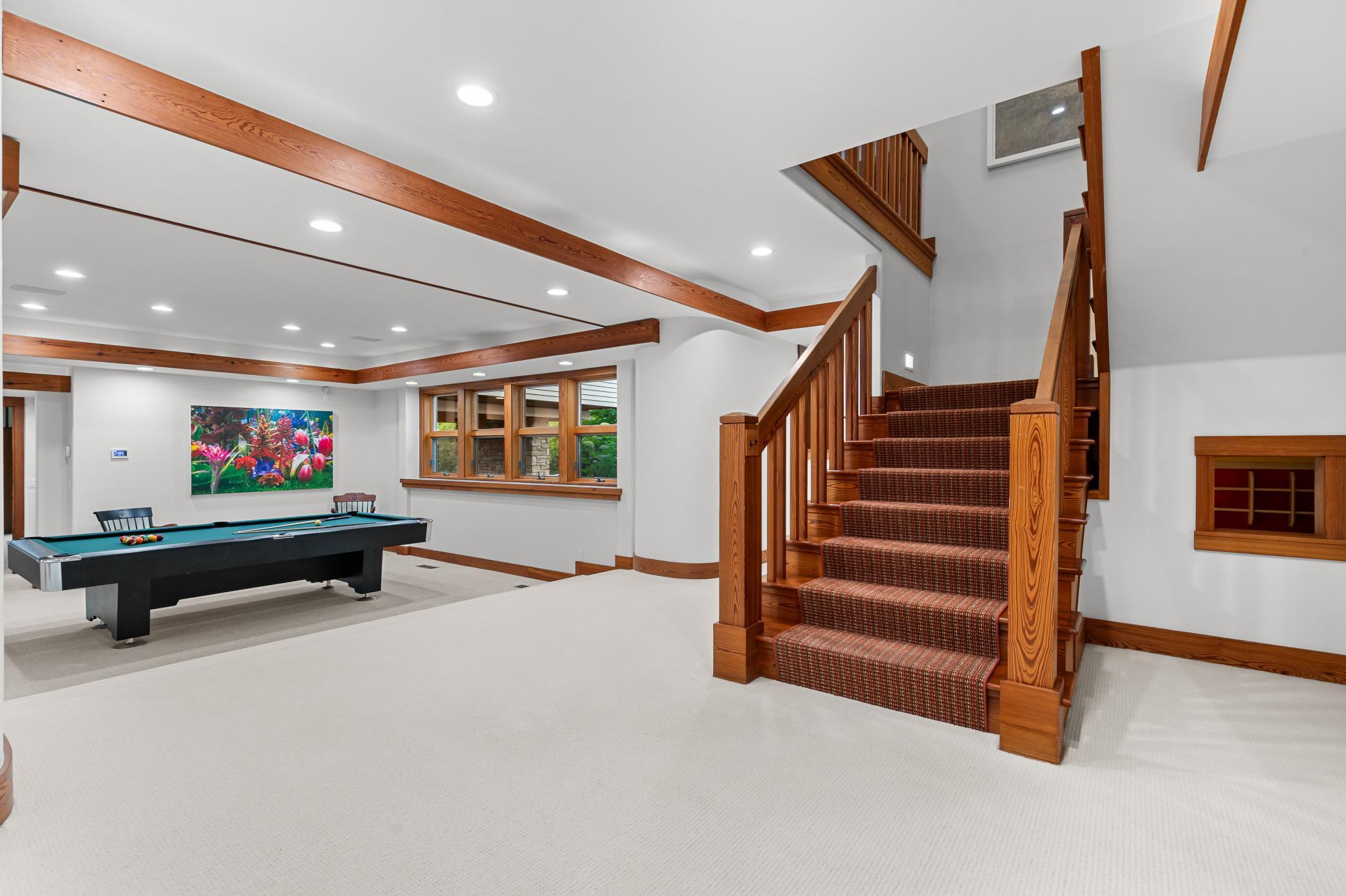 Oversized stair case makes a striking statement as it enters the lower level