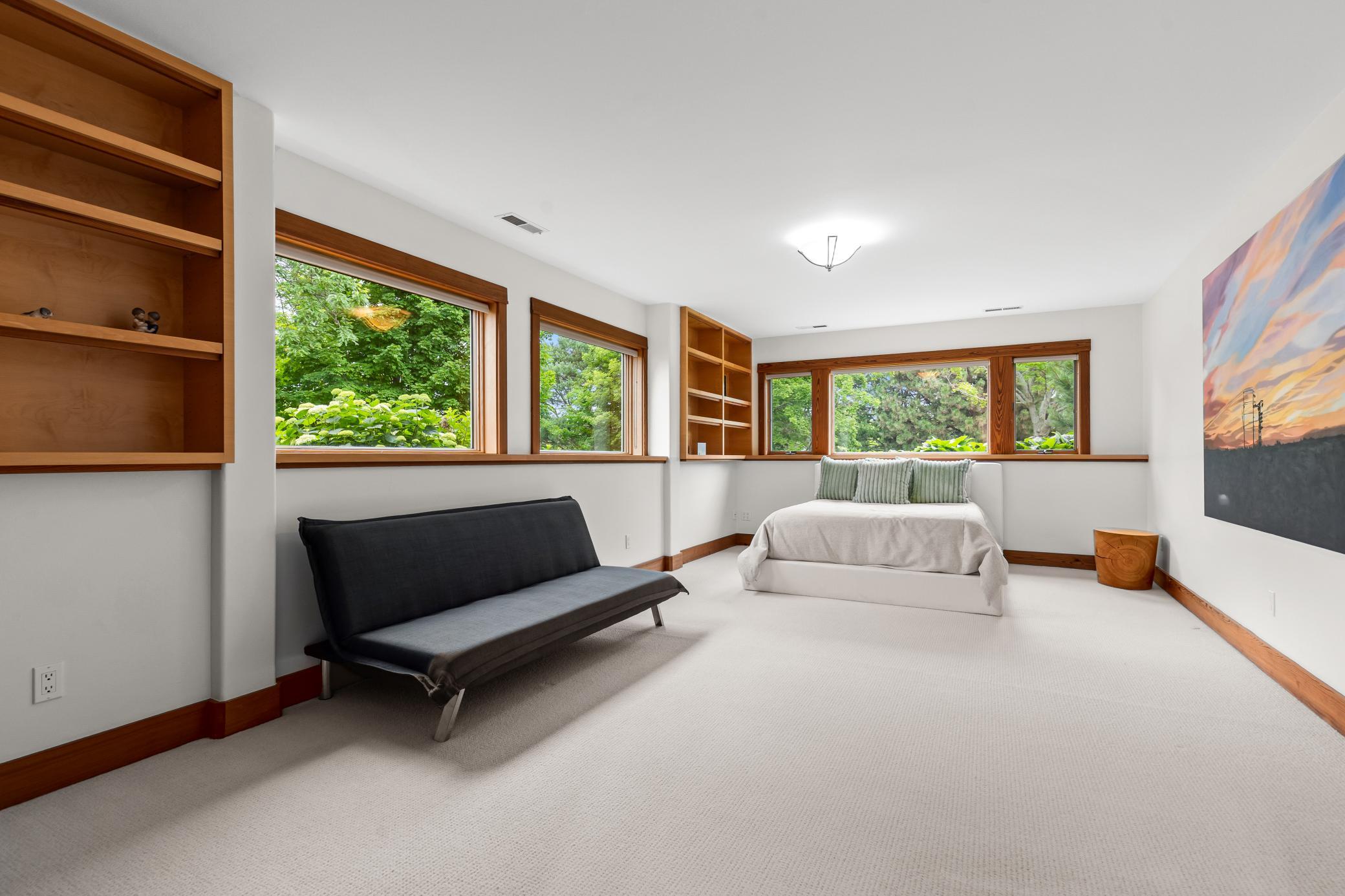 Lower level fourth bedroom with surrounding natural light and built-ins
