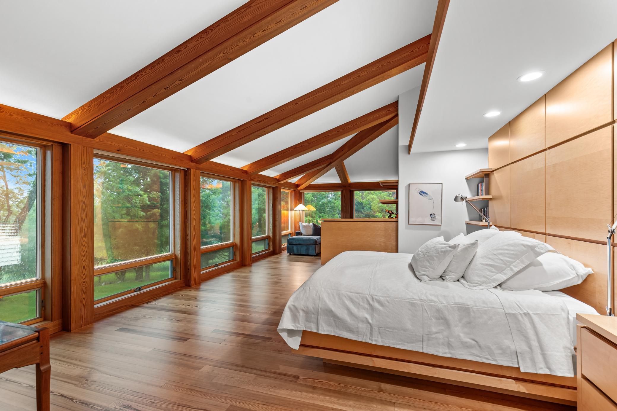 The primary suite with built-in bed and floor to ceiling walls of glass