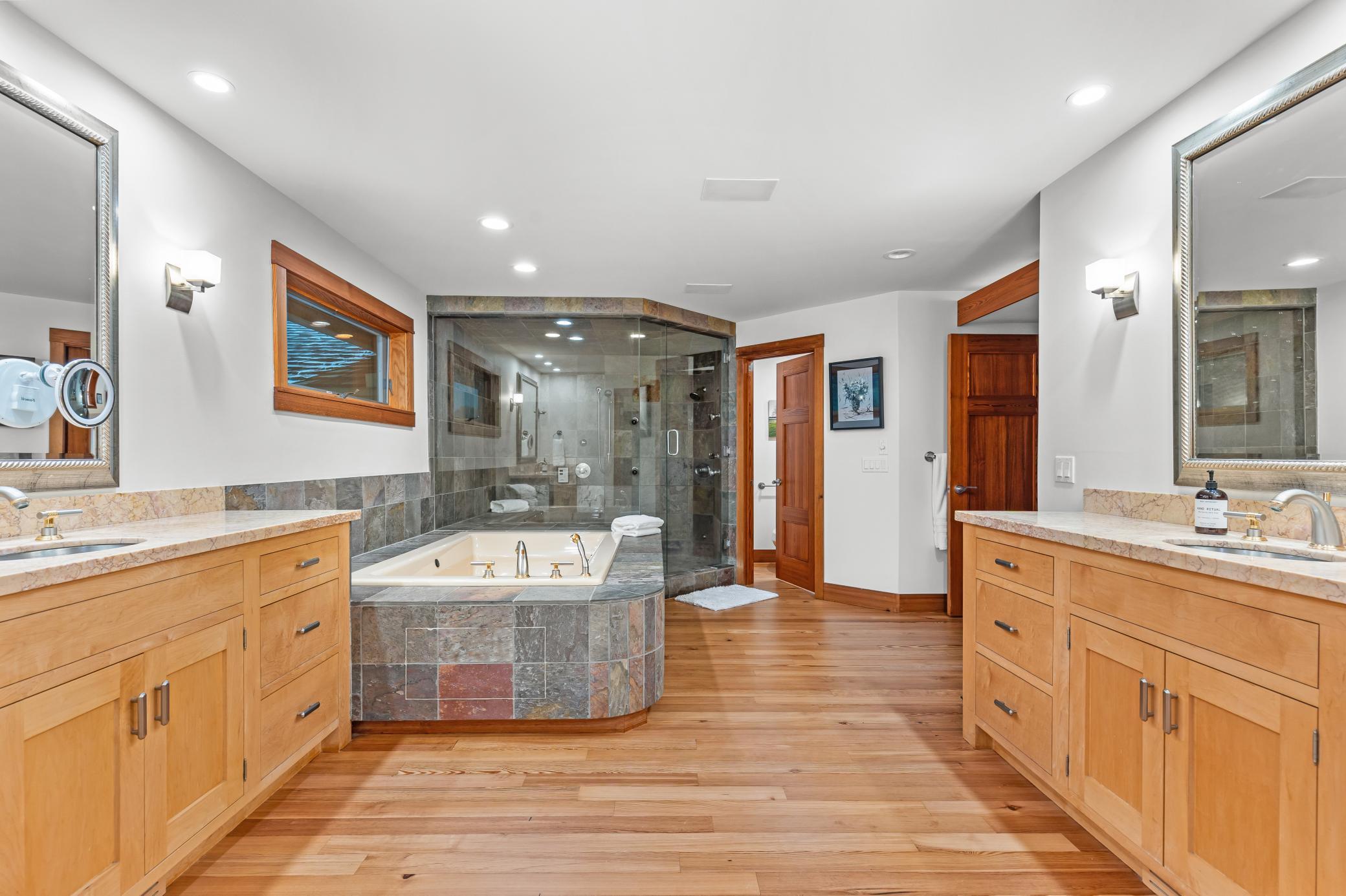 Double vanities, stone countertops, and a soaking tub