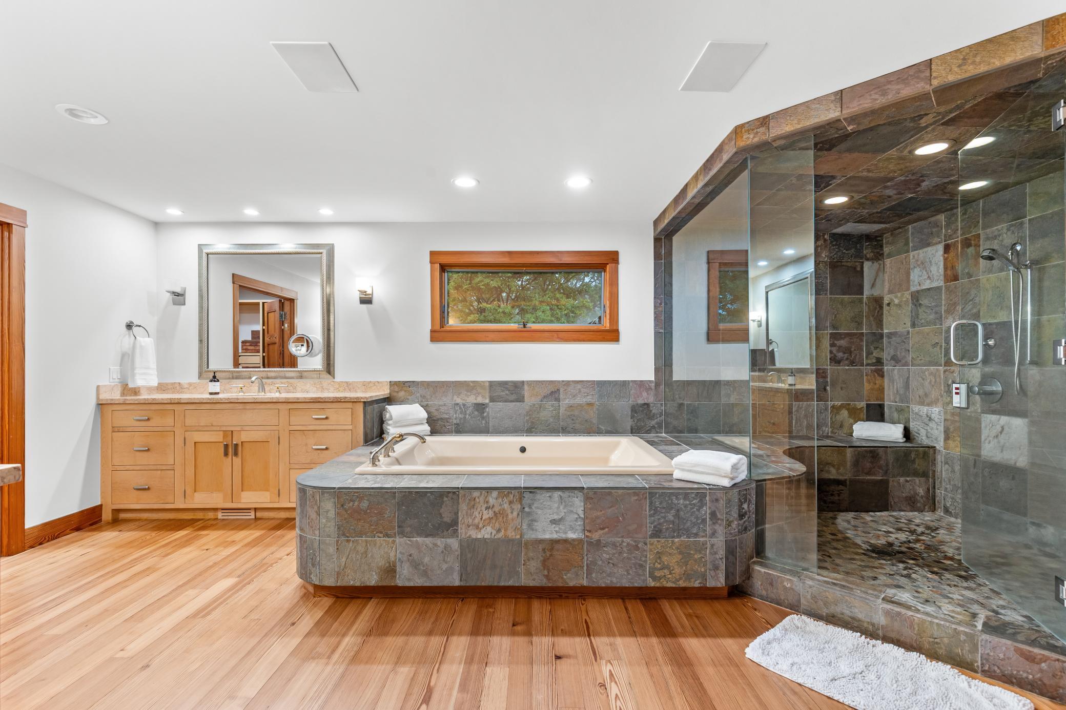 An oversized soaking tub and walk-in shower in the primary bathroom