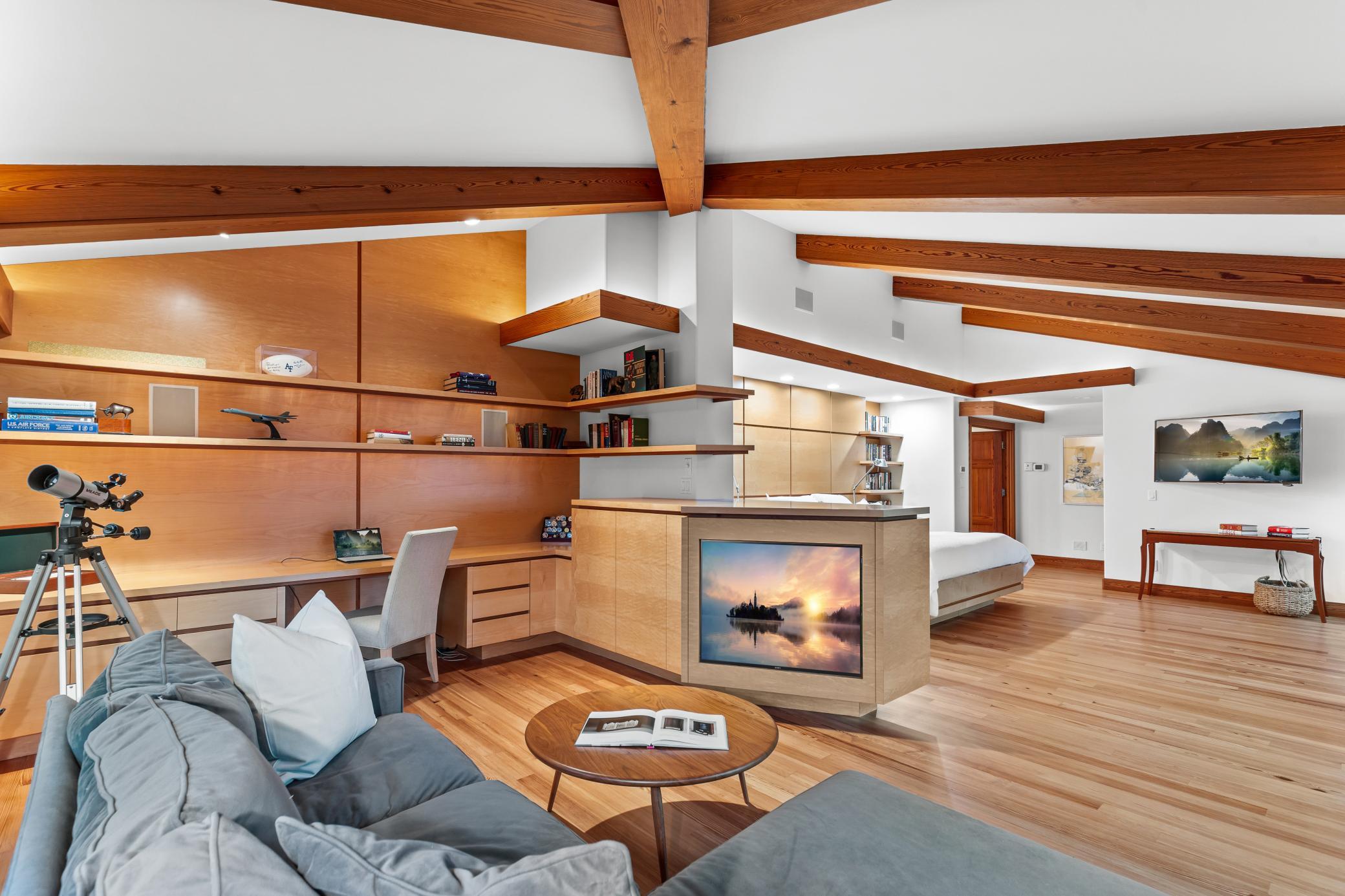 Primary bedroom office with built-in shelving, cabinetry and soft lighting