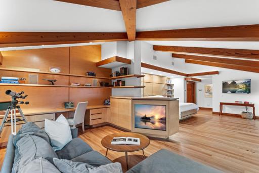 Primary bedroom office with built-in shelving, cabinetry and soft lighting