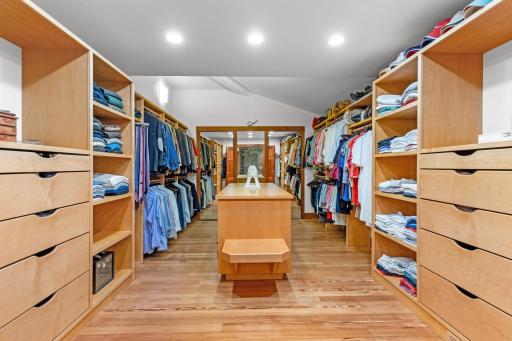 Primary bedroom closet with center storage and surrounding cabinetry