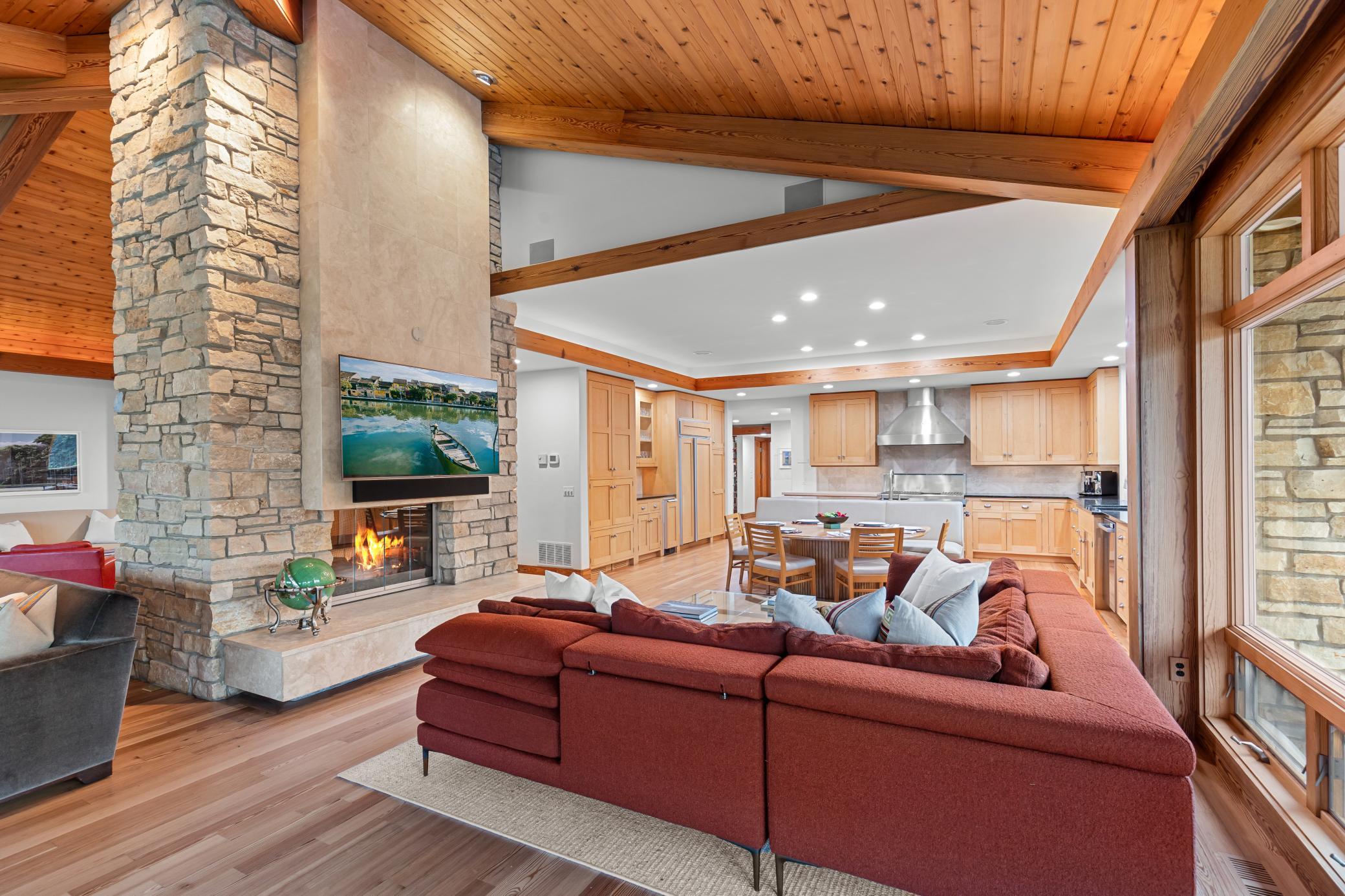 Family room positioned with proximity to the kitchen and surrounded by an impressive limestone fireplace
