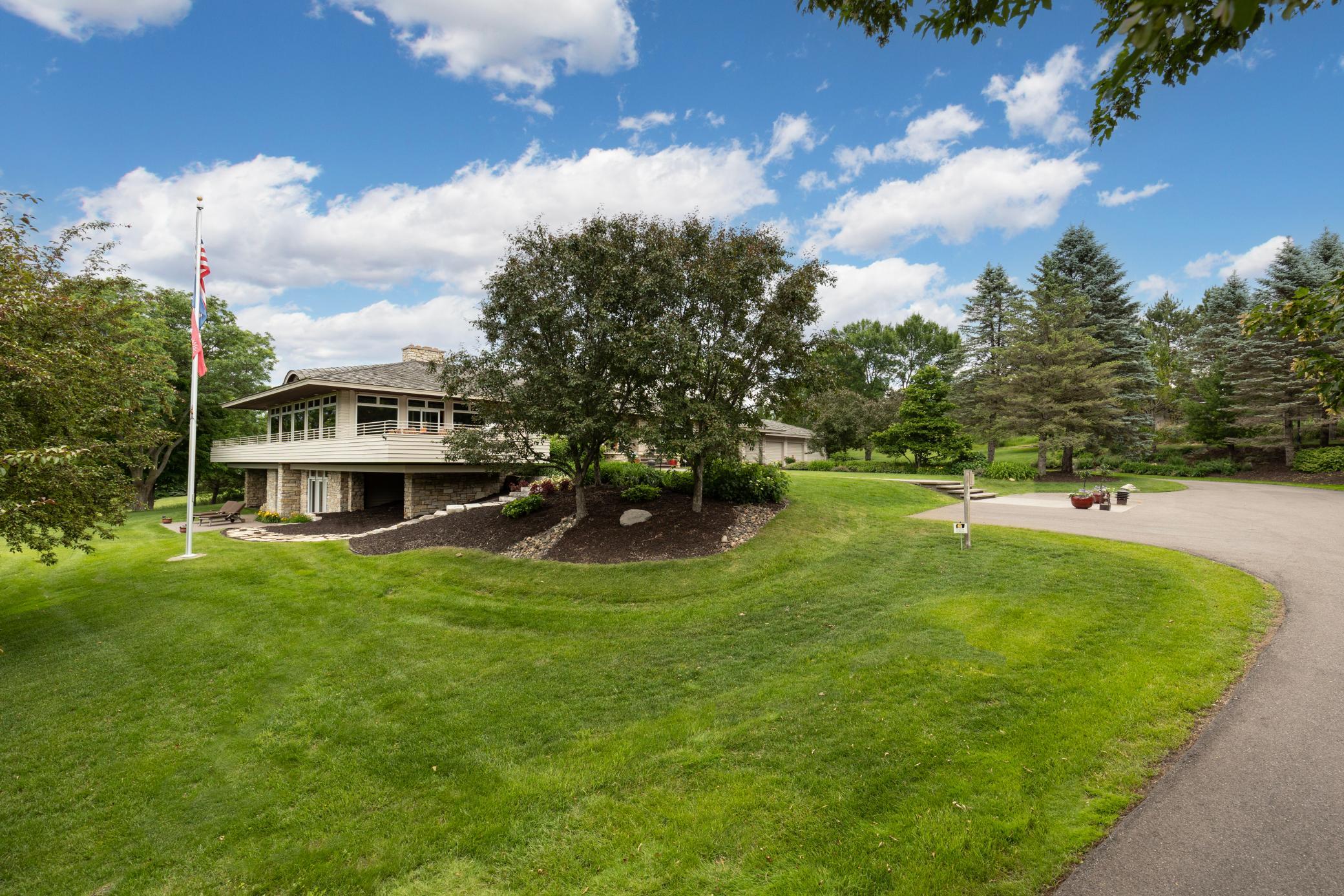 Driveway leads into a heated four car garage, storage lockers, and a work shop
