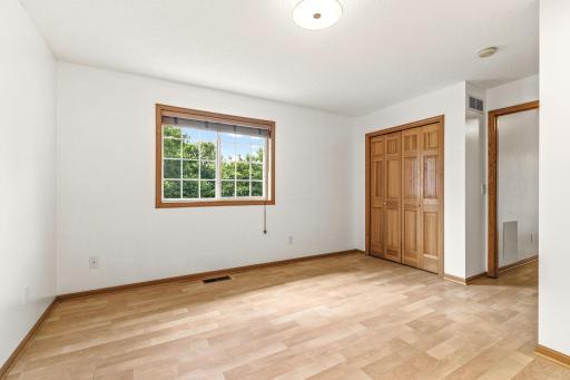 Second view of bedroom #3 showing its bi-fold closet and large window that overlooks the lush and private backyard.