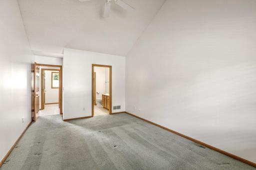 Second view of the main level primary suite showing the entrance to the ensuite 3/4 bath.