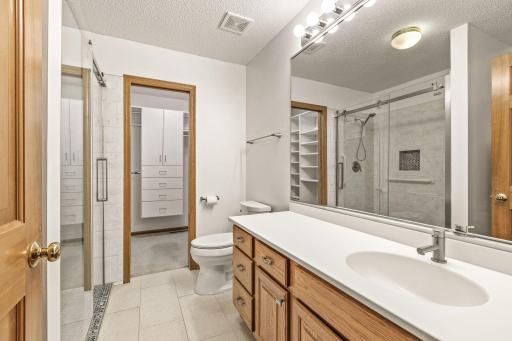 Remodeled ensuite 3/4 bath with a custom tile shower, raised/elongated toilet, cultured marble vanity with new faucet and a convenient furniture niche located behind the bathroom door.