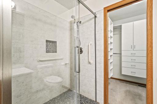 Fabulous oversized shower with no curb for easy entry and large walk-in closet with built-in cabinetry, shelving and hanging space.