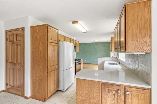 View of kitchen from the informal dining area, also showing the door that leads to the lower level.